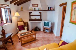 Canillas de AceitunoにあるCasa del Algarroboのソファとテレビのあるリビングルーム