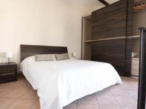 um quarto com uma grande cama branca e uma cabeceira em madeira em Casa Lucrezia em Alba