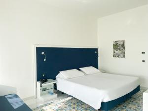 um quarto com uma cama grande e uma cabeceira azul em Regina Cristina em Capri