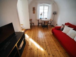 a living room with a red couch and a table at Penzion Dům u barvíře in Český Krumlov