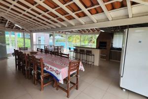 a dining room with a table and a kitchen at Casa Escarpas do lago in Capitólio