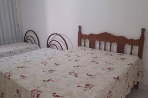 a bedroom with two beds with a floral bedspread at Casa Escarpas do lago in Capitólio +9 photos