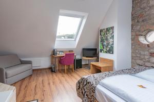 ein Schlafzimmer mit einem Bett, einem Sofa und einem Schreibtisch in der Unterkunft Hotel ten Hoopen Restaurant Deele in Warburg