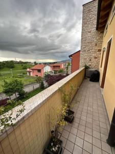 einen Balkon mit Topfpflanzen und einer Ziegelwand in der Unterkunft Prosecco's Hills House in Valdobbiadene