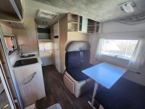 uma pequena cozinha com uma mesa e uma mesa num trailer em autocaravana para 6 plazas posibilidad de moverse o dormir em Montcada i Reixac