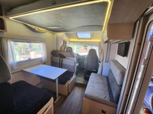 uma vista interior de uma caravana com uma mesa em autocaravana para 6 plazas posibilidad de moverse o dormir em Montcada i Reixac