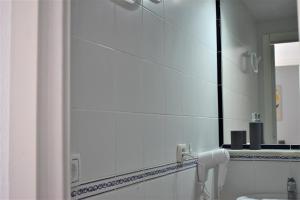 a bathroom with a mirror and a sink at Apartamento Puertomar in El Puerto de Santa María