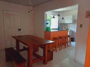 a kitchen with a wooden table and a group of stools at Vila Neto in Uruçuca