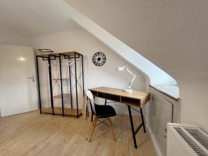 einen Schreibtisch mit einer Lampe und einer Uhr an der Wand in der Unterkunft Komfortable und gemütliche Wohnung mit 2 SZ in Mönchengladbach