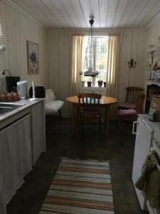 a kitchen with a table and a table and chairs at Lillemyrsgården in Forshaga