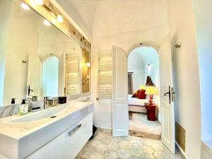 un bagno con un grande lavandino e un grande specchio di Lella Kmar B&B avec piscine Sidi Bou Said a Sidi Bou Saïd