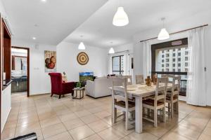 a kitchen and living room with a table and chairs at Modern 3BR Flat in the Heart of Dubai JBR in Dubai