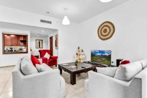 a living room with two white chairs and a table at Modern 3BR Flat in the Heart of Dubai JBR in Dubai
