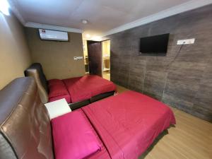 a hotel room with two beds and a flat screen tv at Tamara Guest House in Tioman Island