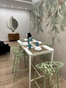 a table with four chairs and a mirror in a room at Napoli centro - Di&da guest house in Naples