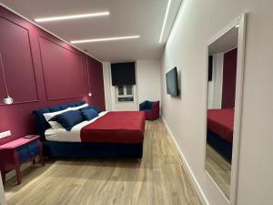 a bedroom with a bed and a red wall at Napoli centro - Di&da guest house in Naples +23 photos