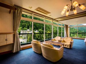 ein Wohnzimmer mit Stühlen und einem großen Fenster in der Unterkunft Yukai Resort Premium Unazuki Grand Hotel in Kurobe