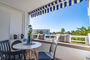 a balcony with a table and chairs and a window at OASIS PLAYA DEL INGLES 324 by Homestaygrancanaria in San Bartolomé de Tirajana