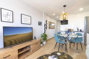 a living room with a large television and a table at OASIS PLAYA DEL INGLES 324 by Homestaygrancanaria in San Bartolomé de Tirajana
