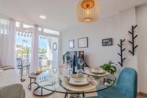 a living room with a glass table and chairs at OASIS PLAYA DEL INGLES 324 by Homestaygrancanaria in San Bartolomé de Tirajana