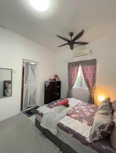1 dormitorio con 1 cama y ventilador de techo en Embun Marissa Melaka Luxury Homestay, en Melaka