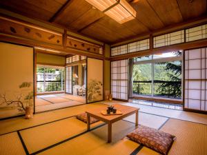 a living room with a table and a large window at Yukai Resort Premium Unazuki Grand Hotel in Kurobe