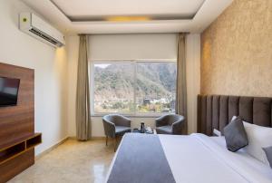 a hotel room with a bed and a large window at Vyom Boutique Hotel Rishikesh in Rishīkesh