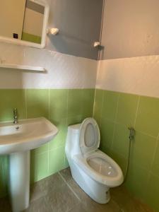 La salle de bains est pourvue de toilettes blanches et d'un lavabo. dans l'établissement Phi Phi Goodview Bungalow, sur les Îles Phi Phi