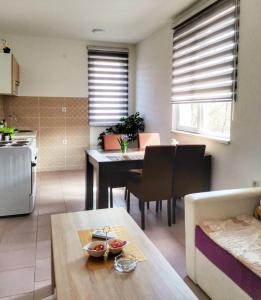 uma cozinha e sala de estar com uma mesa e uma sala de jantar em Apartman Poljčić Višegrad em Višegrad