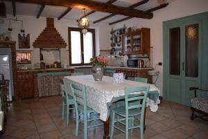 波佐倫戈的住宿－Casa Vacanze Cascina Campagnola，厨房配有一张桌子,上面放着花瓶
