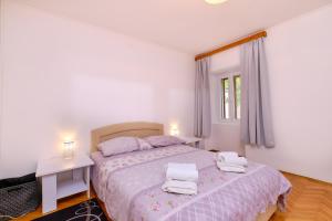 a bedroom with a bed with two towels on it at Apartments Antonella in Veli Lošinj +52 photos