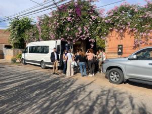 um grupo de pessoas à frente de uma carrinha branca em Riad Rime Garden Marrakech em Marraquexe