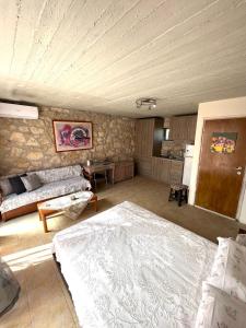 a living room with a large bed and a kitchen at Katerina's Rest Stone Ηouse in Khárakas