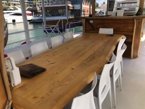 a wooden table with white chairs and a boat at הספינה של אריק in Eilat