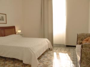 una camera con un letto e una sedia e una finestra di Residenza Cavour - Appartamento AGAVE a Levanto