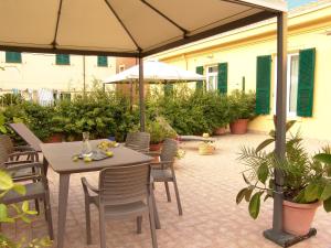 un patio con mesa, sillas y sombrilla en Residenza Cavour - Appartamento AGAVE en Levanto