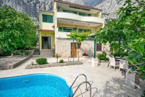 a villa with a swimming pool in front of a house at Holiday Home Vrcani in Veliko Brdo
