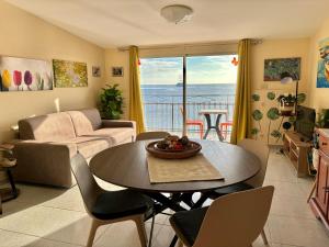 Sala de estar con mesa y vistas al océano en LA MANSARDA, en Giardini Naxos
