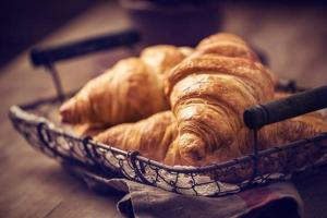 a basket filled with croissants on top of a table at Hotel Appartements Graf Hartwig in Schenna