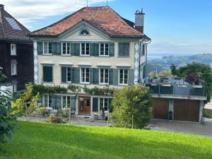 a large house on top of a green hill at Allegra Appenzell in Trogen