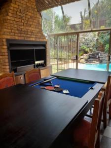 a ping pong table in a room with a swimming pool at Chappel Hide Out in Germiston