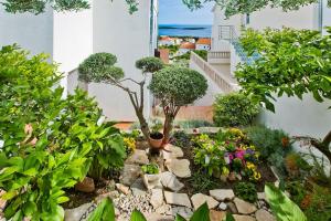 a garden with flowers and trees in a building at Apartman Tino with two sunny terace in Hvar