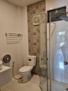 a bathroom with a toilet and a glass shower at Must Come Boutique Hotel in Ban Nam Khong