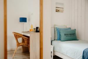 a bedroom with a bed and a table and a chair at Le Clos De La Roche in Goven