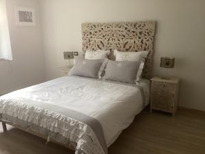 een slaapkamer met een groot wit bed en 2 nachtkastjes bij Charmes de la Forêt in Huelgoat