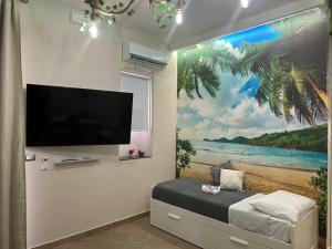 Camera con TV e murale della spiaggia di Tropical Holiday House a Catania