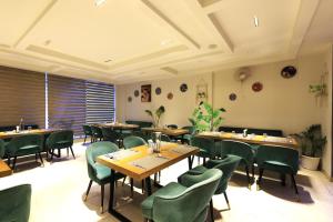 a restaurant with wooden tables and green chairs at Vyom Boutique Hotel Rishikesh in Rishīkesh