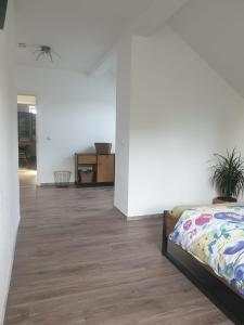 um quarto com paredes brancas e piso em madeira em Ferienwohnung Witten Gederbach em Witten