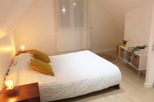 una camera da letto con un grande letto bianco con cuscini gialli di New contemporary house, Orsay-Saclay near Paris and Versailles 35m2 a Orsay
