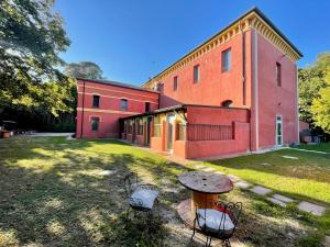 a building with a table and chairs in the yard at Residence Villa Masi in Ferrara